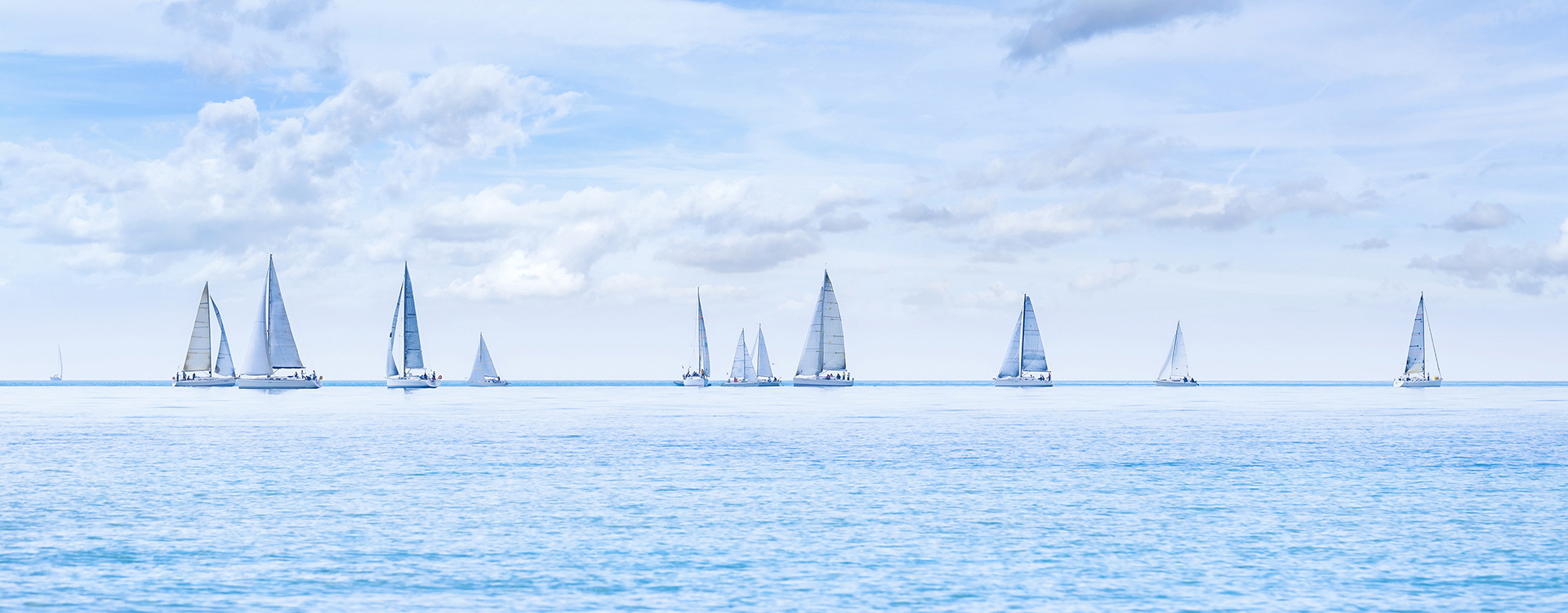 Sailing boat yacht or sailboat group regatta race on sea or ocean water. Panoramic view.